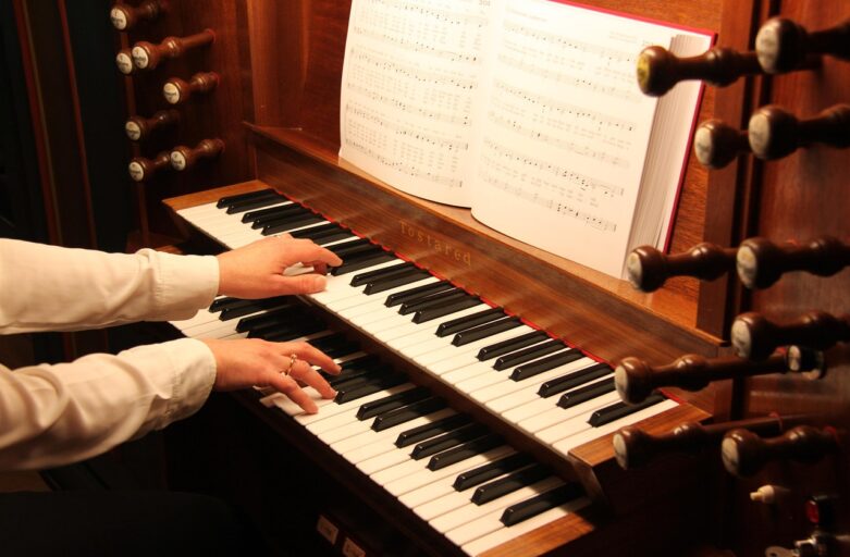 hands on organ keyboard with sheet music