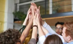 people with hands raised touching together